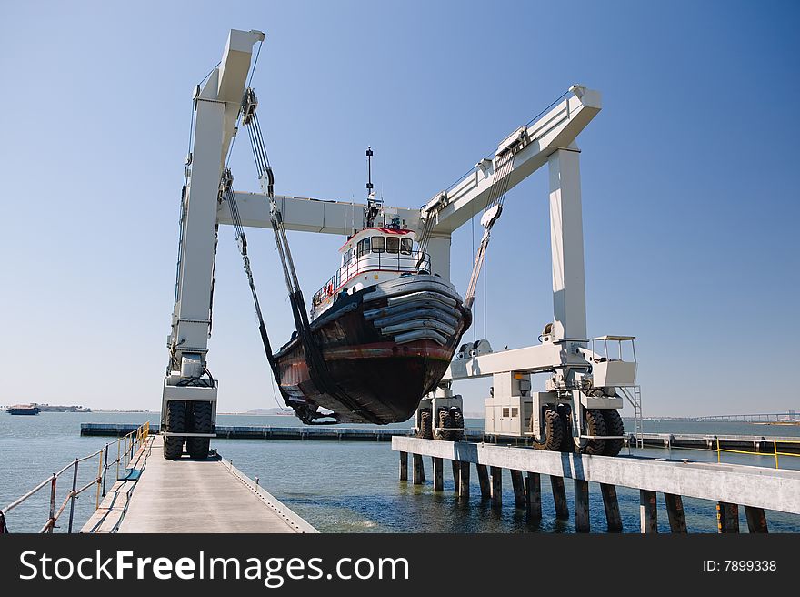 Tug Boat being lifted out of the water going into dry dock