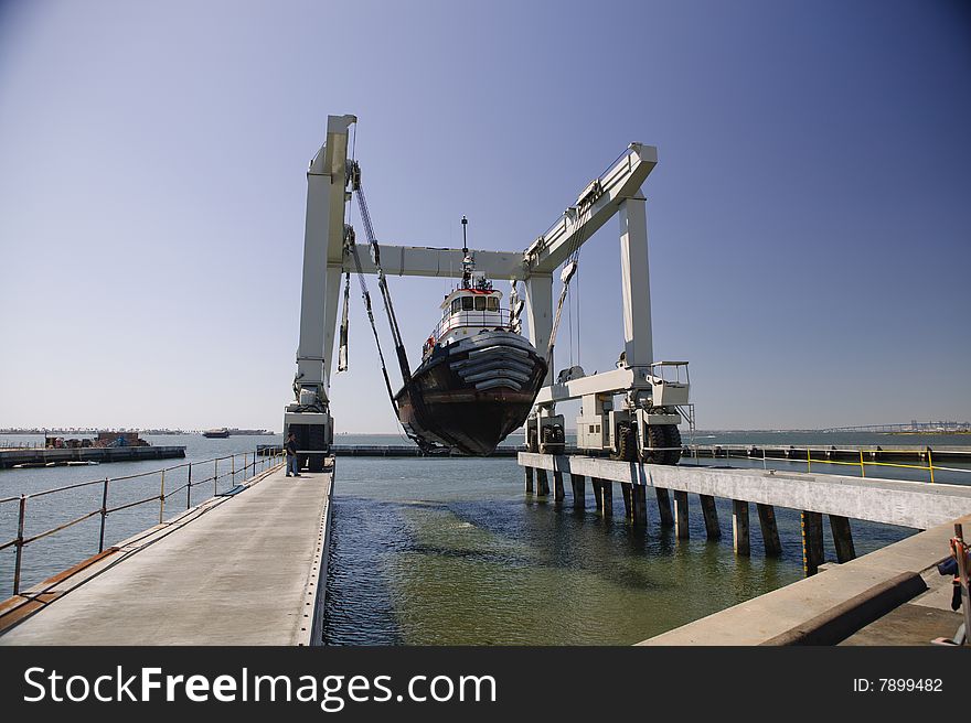 Tug Boat being lifted out of the water going into dry dock