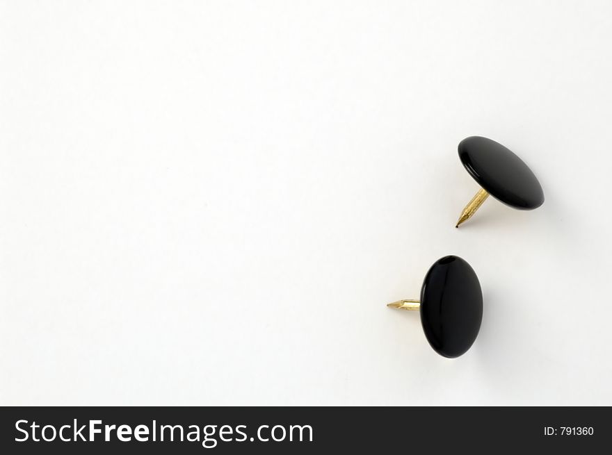 Close-up of two thumbtacks on white background