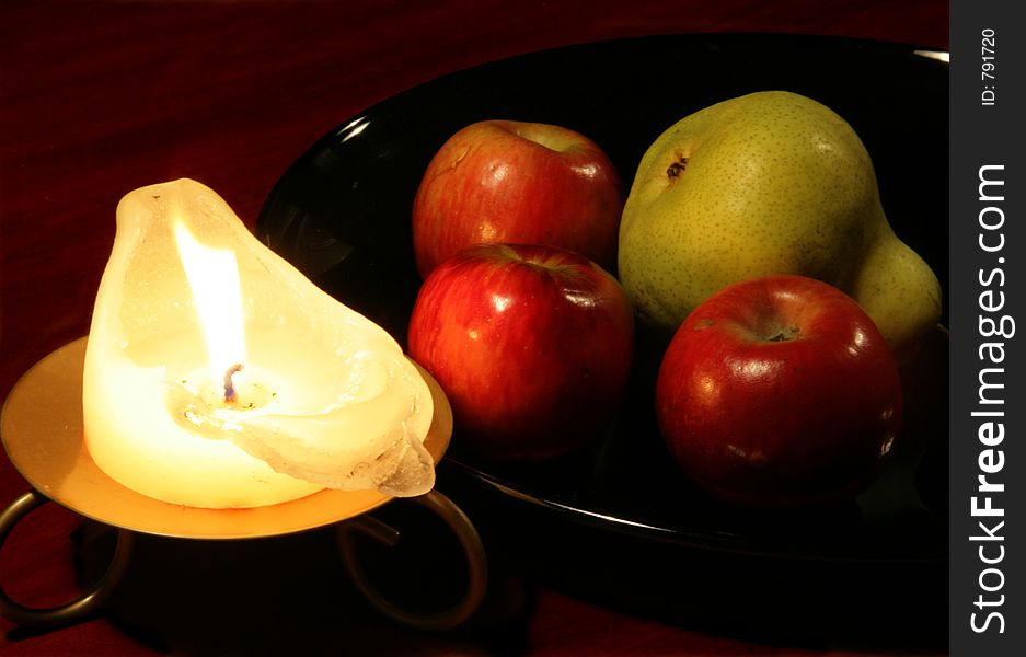 Red apples, a pear and a candle