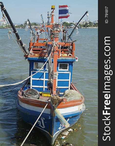 Blue, wooden fishing boat at the pier in Naklua, Chonburi province, Thailand