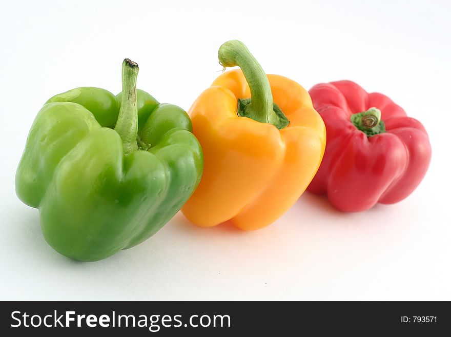 Green yellow and red peppers on a white background