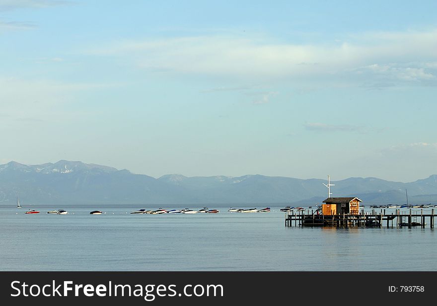 Boats on a lake next to a pier.