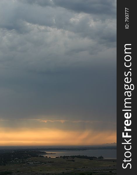 Rain in the distance with the sun fading over a lake. Rain in the distance with the sun fading over a lake.