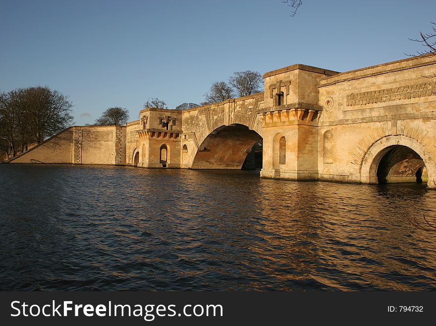 Stone bridge with arches over a lake. Stone bridge with arches over a lake