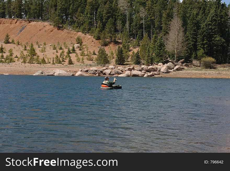 Fisherman fishing for trout in belly boat. Fisherman fishing for trout in belly boat