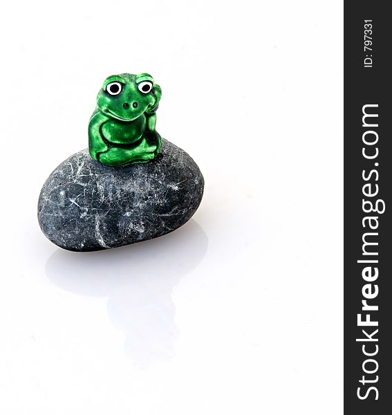 A frog sitting on a rock isolated on a clipping path. A frog sitting on a rock isolated on a clipping path.
