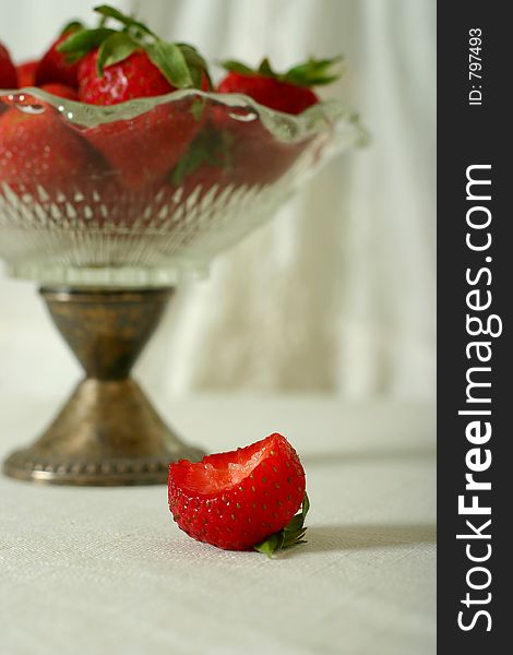 Strawberries in vintage glass bowl, off white casual setting. Strawberries in vintage glass bowl, off white casual setting