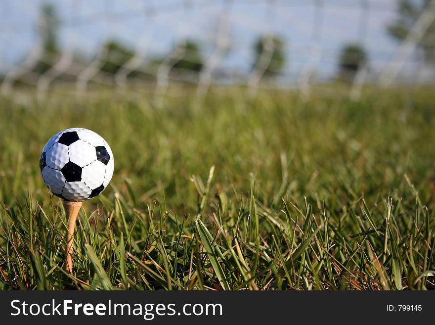 Soccer ball on tee in front of goal. Soccer ball on tee in front of goal