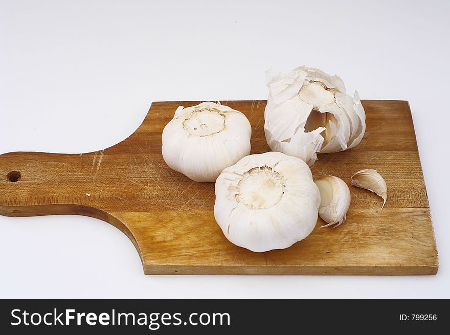 Garlic on a wooden cooking plate, isolated. Garlic on a wooden cooking plate, isolated