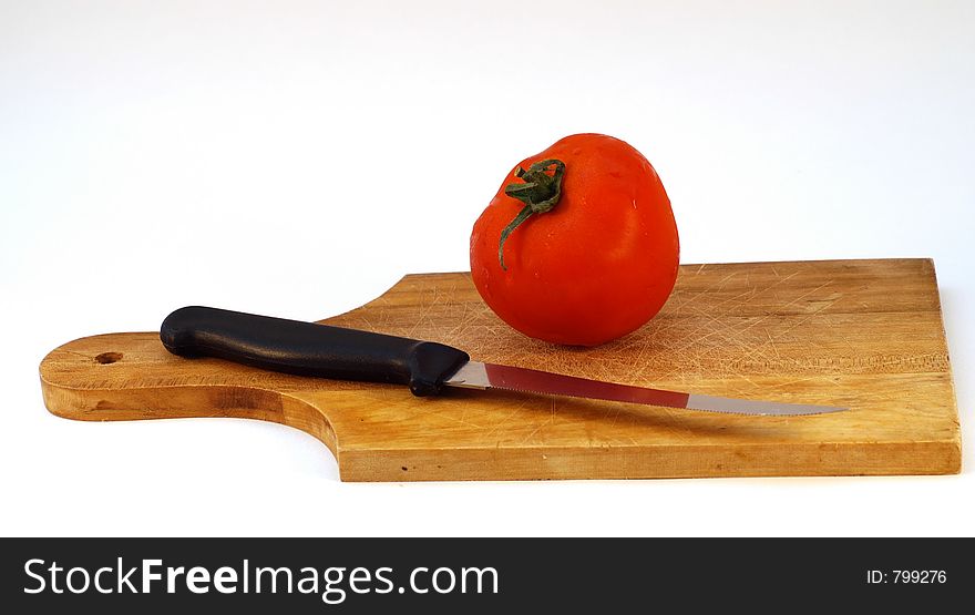 Tomato with a knife on a plate, isolated