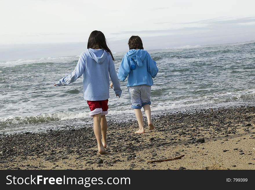 Two young girls walk down the beach.  High Res. Two young girls walk down the beach.  High Res