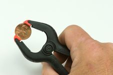 Hand Holding Penny In Clamp Royalty Free Stock Photo