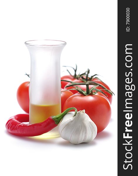 Tomatoes, hot pepper, oil in glass and garlic isolated on a white background. Tomatoes, hot pepper, oil in glass and garlic isolated on a white background.