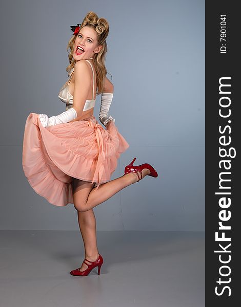 Cute young girl burlesque dancer in peach crinoline & satin bullet bra