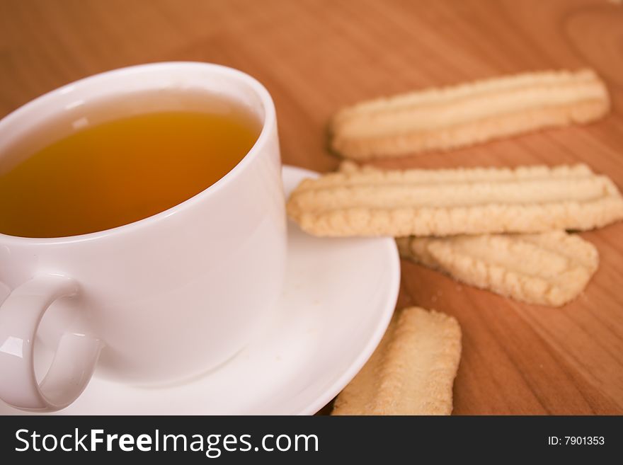 Cup of tea and some cookies on wooden table