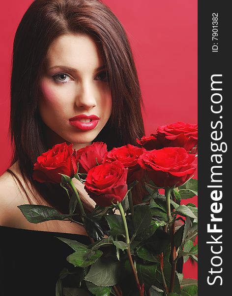 Close-up studio portrait of a beautiful sexy woman with red rose, shoot  on red background
