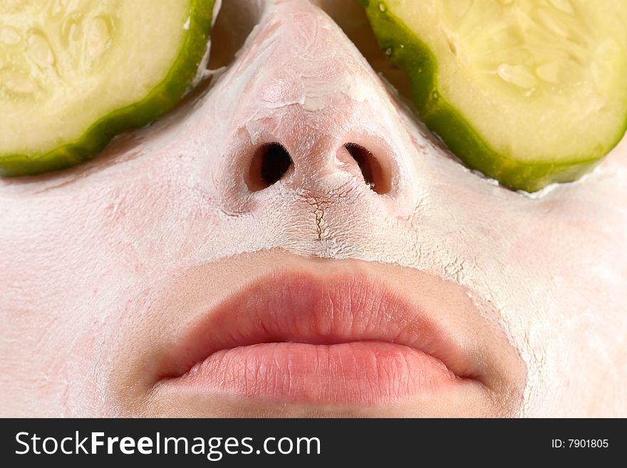 Woman with cucumbers and face mask. Woman with cucumbers and face mask