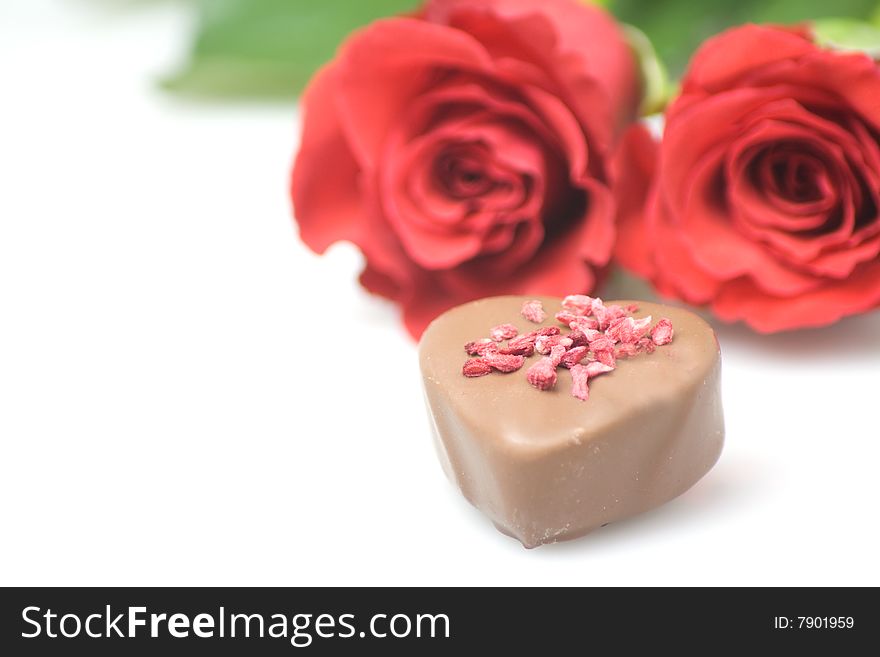 Red roses with a chocolate heart  romantic concept. Red roses with a chocolate heart  romantic concept