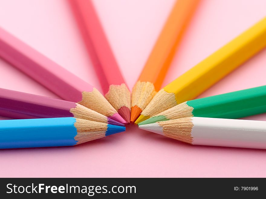 Semicircle of pencils on pink background