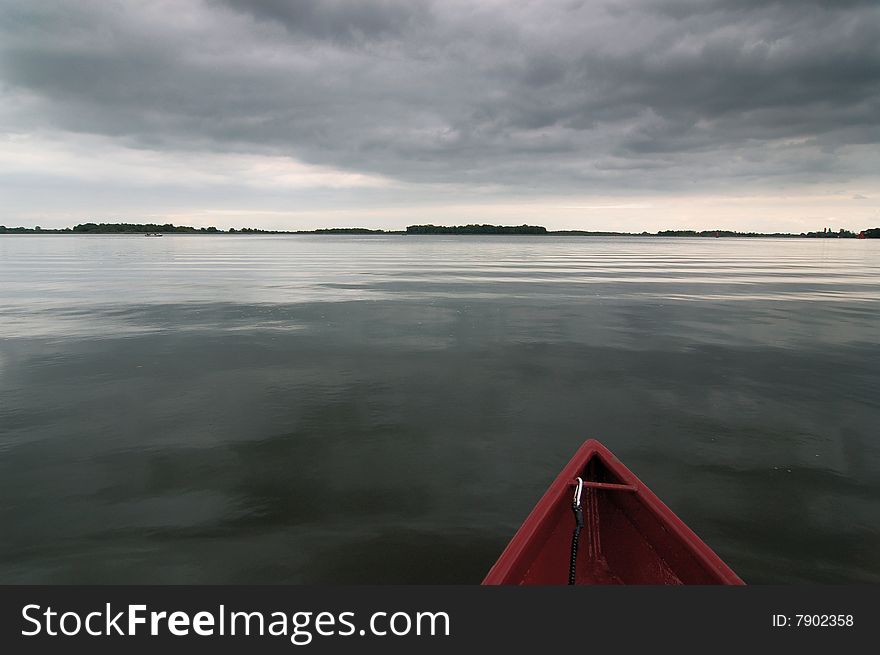 A sail boat on a quiet lake.