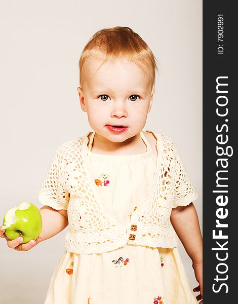 Studio portrait of a little girl holding a green apple. Studio portrait of a little girl holding a green apple