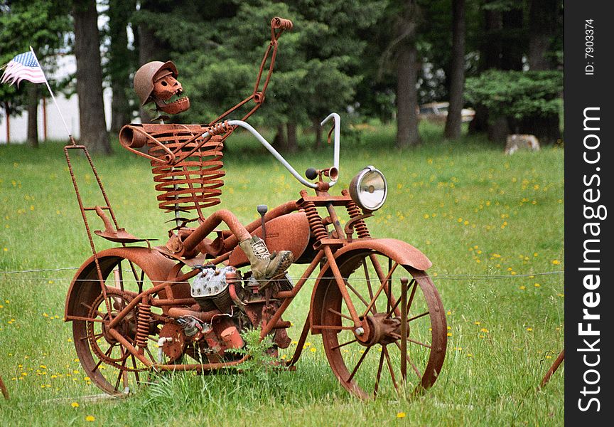 This is a still life of a motorcycle with a iron man,made out of old motorcycle parts and junk.