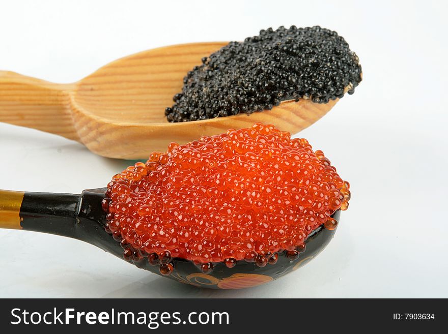 Two wooden spoons with red and black caviar. Two wooden spoons with red and black caviar