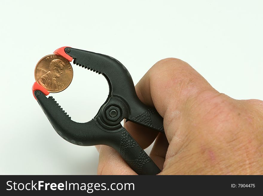 Hand holding clamp with penny on it. Hand holding clamp with penny on it