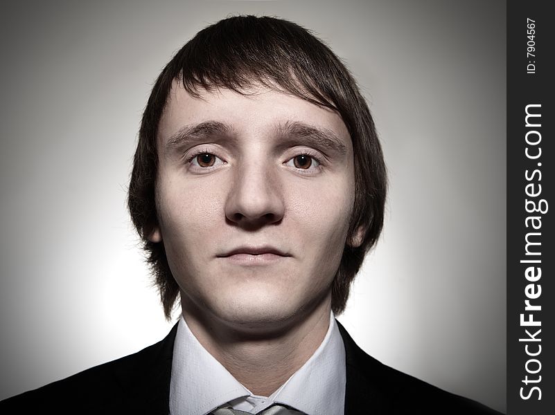 Face of businessman from wide angle lens on gray background