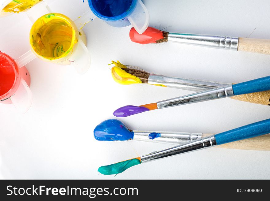 Stock photo: an image of five paintbrushes and three paints. Stock photo: an image of five paintbrushes and three paints