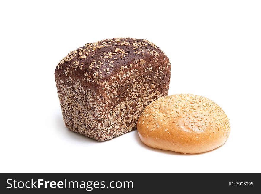 Loaf of bread and bun full of seeds isolated on a white background. Loaf of bread and bun full of seeds isolated on a white background.