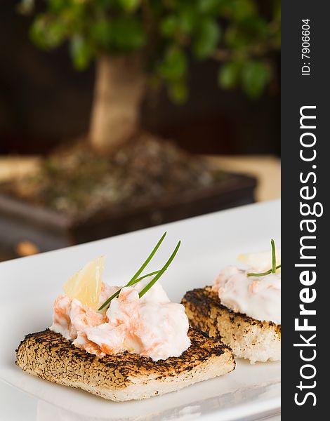 Salmon and creme fraiche toasts with chives to garnish. Salmon and creme fraiche toasts with chives to garnish