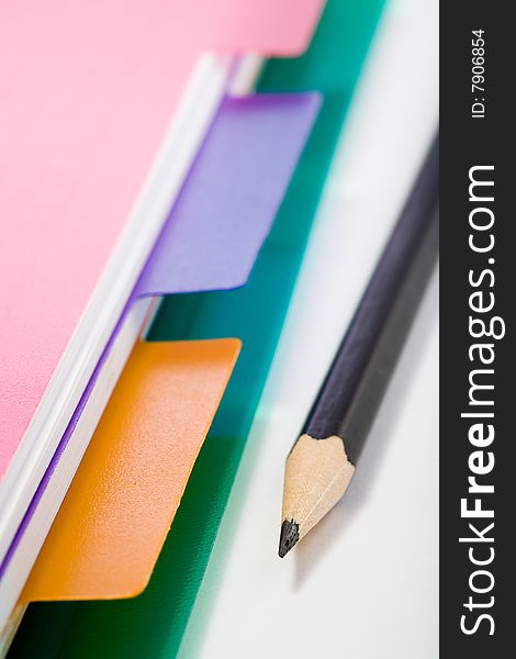 Stock photo: office theme: an image of part of pink notebook and a pencil. Stock photo: office theme: an image of part of pink notebook and a pencil