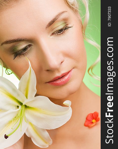 Beautiful young woman with lily flower. Close-up portrait