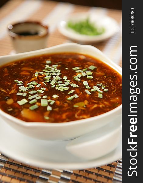 Dark spring vegetable soup with leek on plate