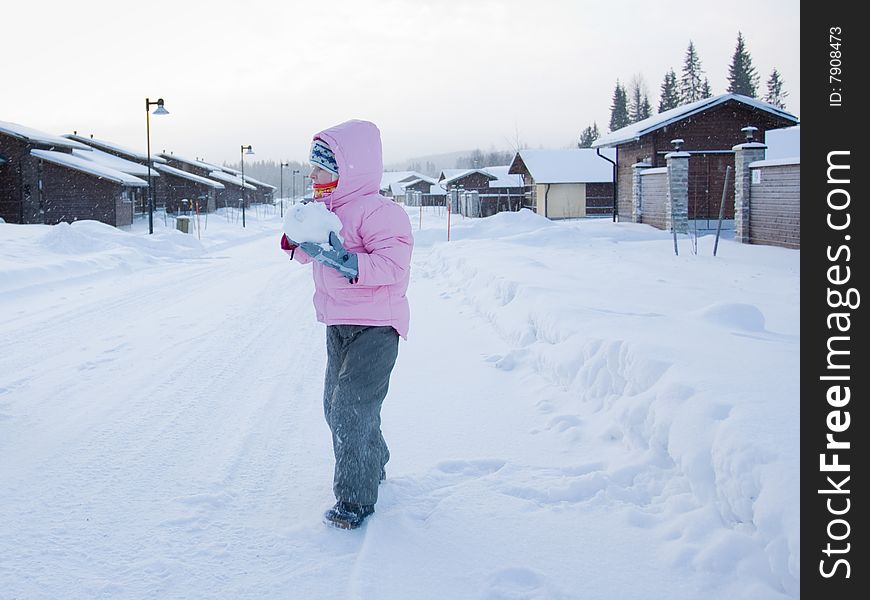 Little girl having fun in snow with piece of snow in her hands. Little girl having fun in snow with piece of snow in her hands