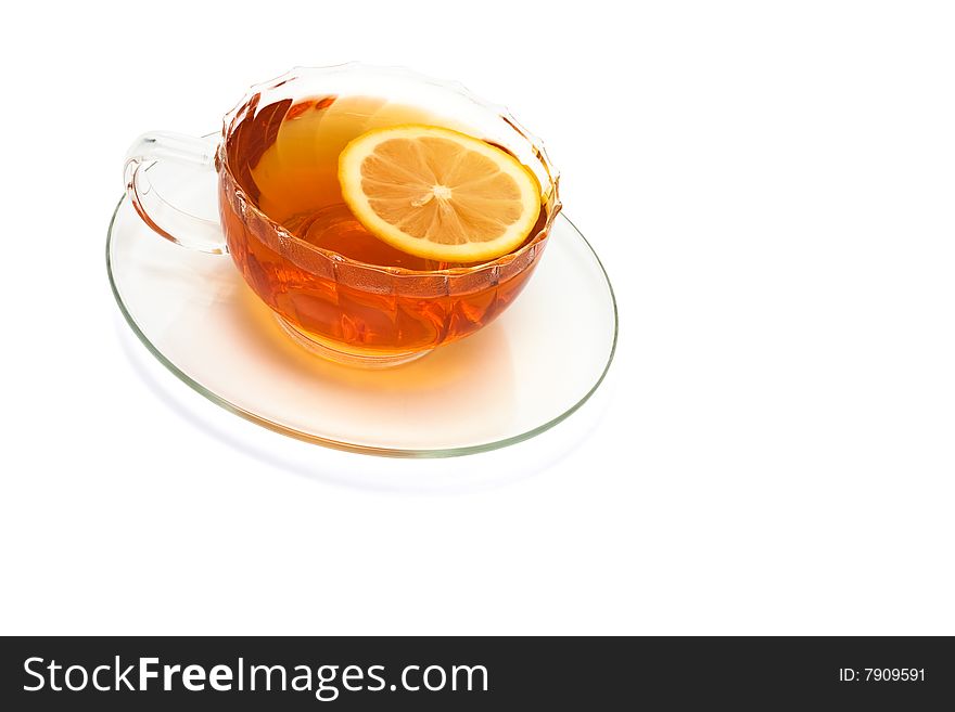 Glass cup with tea and a lemon on a white background