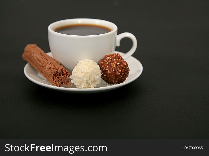A deiciious cup of black coffee with a side of chocolate. A deiciious cup of black coffee with a side of chocolate