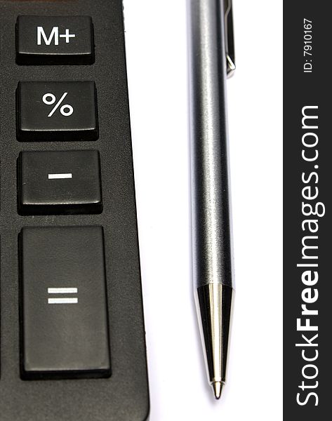 Part of the keyboard of the calculator and metal pen. Part of the keyboard of the calculator and metal pen