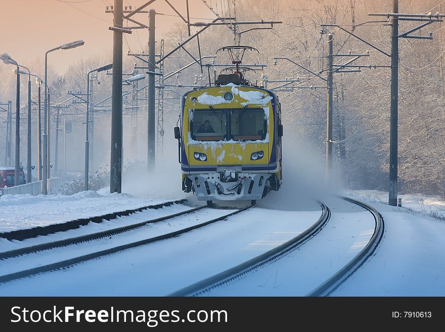 Incoming suburban train in the misty winter sunset