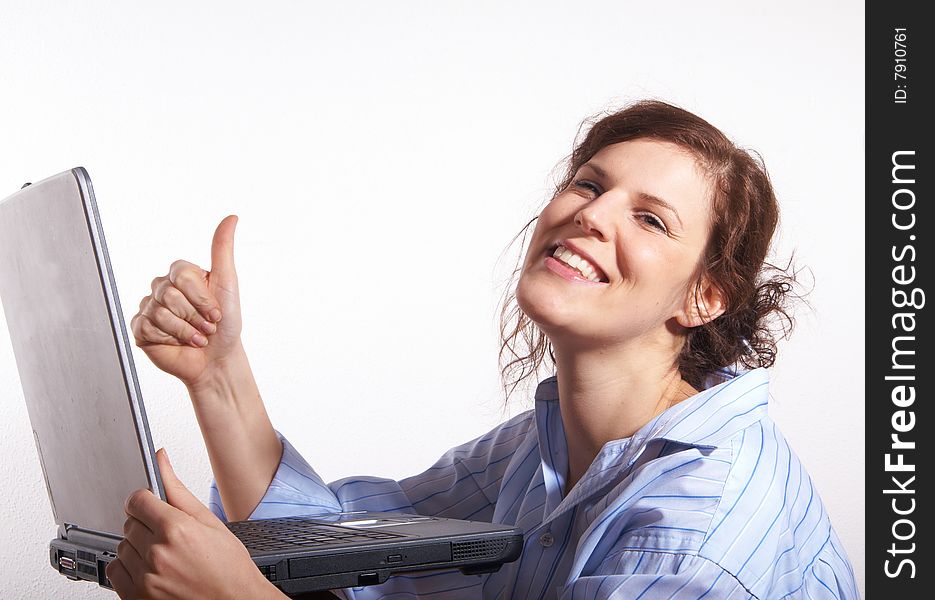 A young woman at home sitting on the floor with her laptop. She is very happy and gives a thumb up sign. A young woman at home sitting on the floor with her laptop. She is very happy and gives a thumb up sign.