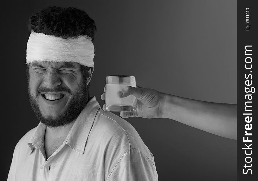 A man with a bandage on his head and a hand reaching in to offer water. . A man with a bandage on his head and a hand reaching in to offer water.