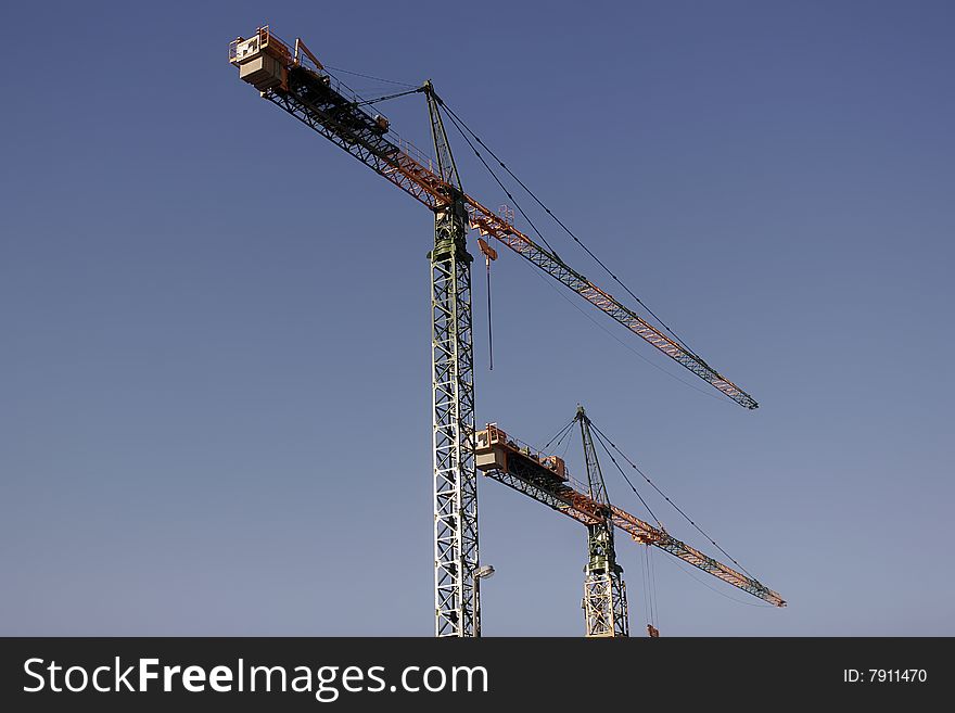 Two tower cranes at construction field isolated