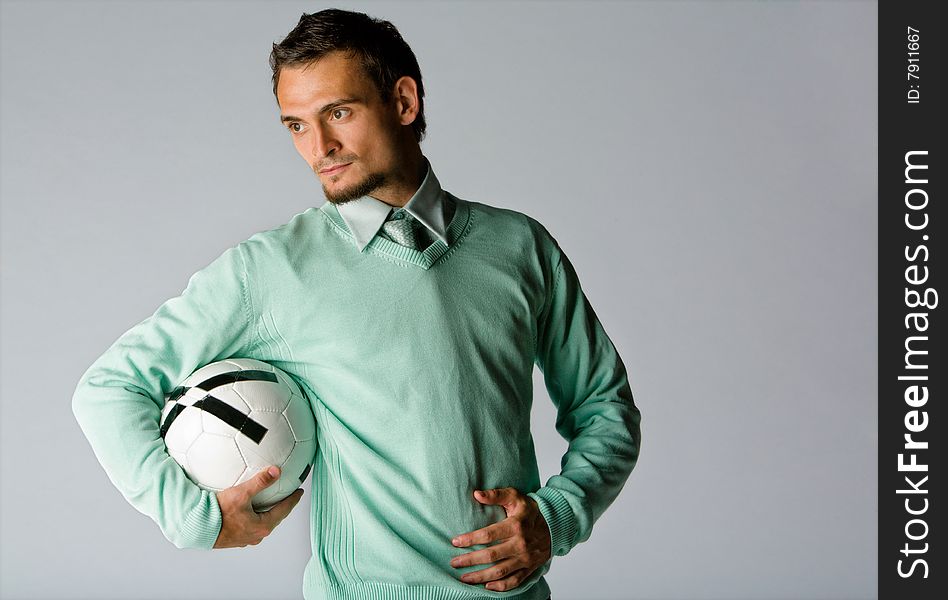 Business professional wearing a tie and sweater holds a soccer ball. Business professional wearing a tie and sweater holds a soccer ball.