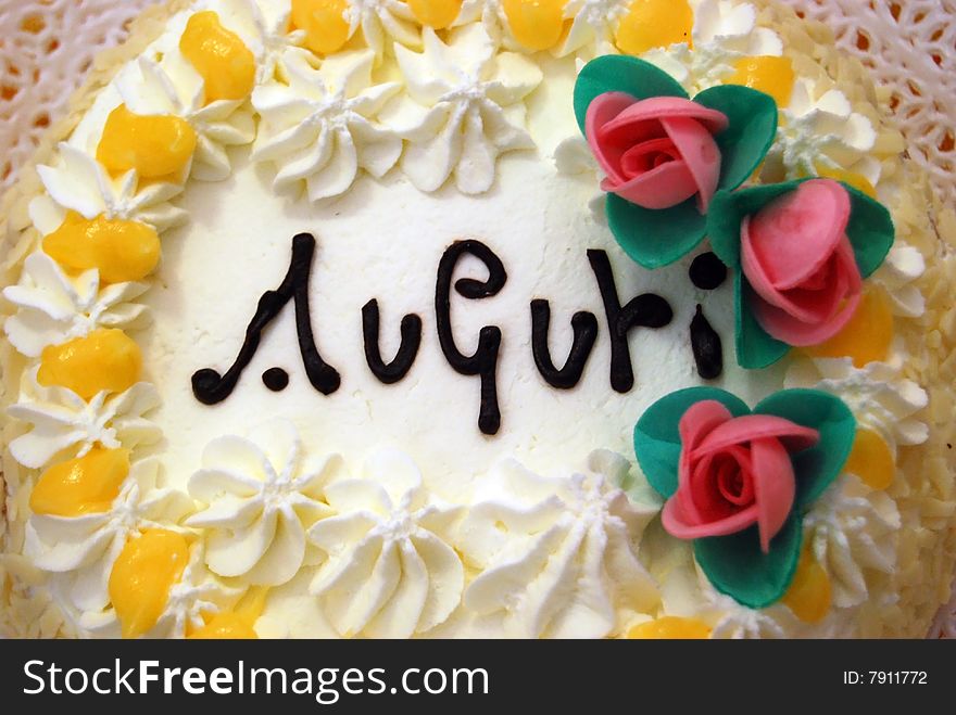 Birthday cake with auguri, cream and little roses