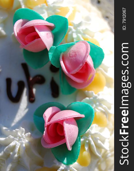 Birthday cake with three little pink roses, close up