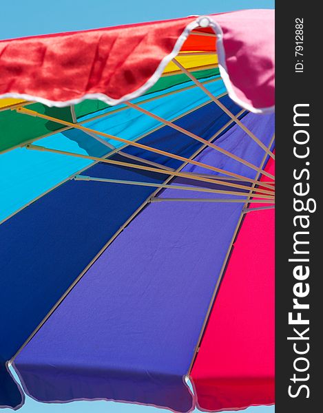Bright colorful beach umbrella against blue sky