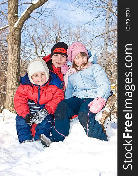 Mum with the son and a daughter sit on snow in park. Mum with the son and a daughter sit on snow in park.