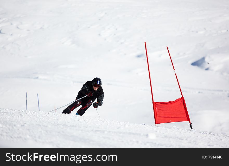 Young skier doing downhill on Giant Slalom course; horizontal orientation, large copy space. Young skier doing downhill on Giant Slalom course; horizontal orientation, large copy space.